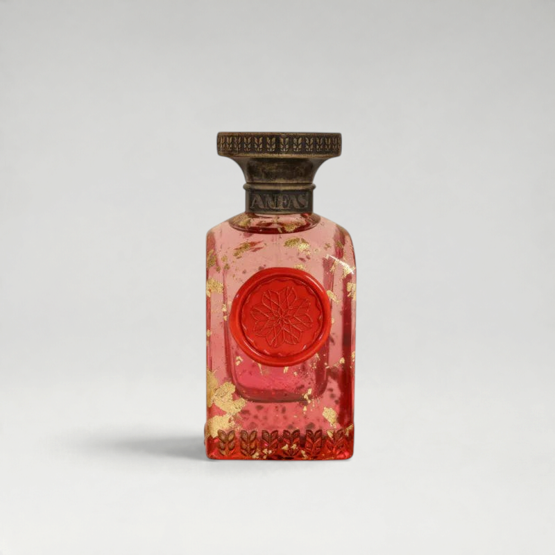 FBYMM AYA parfum in een roze glazen fles met gouden vlokken, een rood zegel en een antieke bronzen dop.