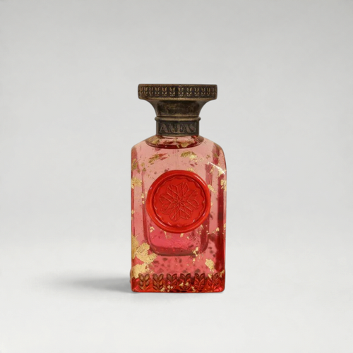 FBYMM AYA parfum in een roze glazen fles met gouden vlokken, een rood zegel en een antieke bronzen dop.